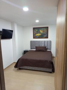 a bedroom with a bed and a flat screen tv at Aparta estudio en Álamos in Pasto
