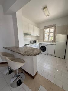a kitchen with a counter and two bar stools at Vilamoura Marina Beach Apartament in Quarteira