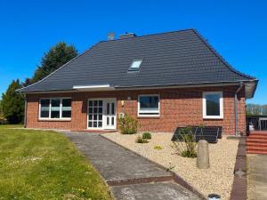 a red brick house with a black roof at Ferienwohnung Neumann in Lentföhrden
