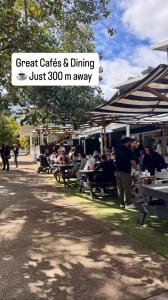 a group of people sitting at tables in a park at Spacious Private 2BR Guest Suite in Gold Coast +5 photos