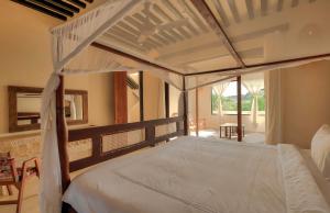 a bedroom with a canopy bed with a balcony at Tulia House Lamu in Lamu +145 photos