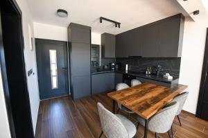 a kitchen with a wooden table and chairs at Luxury Villa with a Private Pool in Hadžići