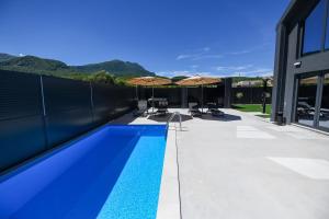 a swimming pool with two umbrellas on a house at Luxury Villa with a Private Pool in Hadžići