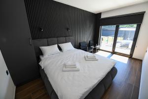 a bedroom with a large bed with white sheets at Luxury Villa with a Private Pool in Hadžići