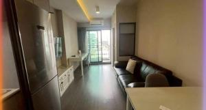 a living room with a leather couch and a large window at Hotel Luxe Elite in Chhatikara