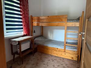 a room with two bunk beds and a desk at Chata Białobrzeg in Białobrzeg Dalszy