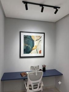 a white chair sitting in front of a blue desk at Espaço inteiro apartamento com escritório in Ananindeua