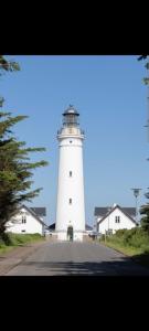 a lighthouse sitting on the side of a road at Casa Bonita helt ny lejlighed med eget toilet in Hjørring