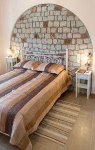 a bedroom with a large bed with a stone wall at Dreamcatcher Maizonette No. 3 in Kalavrita