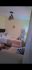 a bedroom with two beds and a chandelier at Faymu Homes in Kitengela 