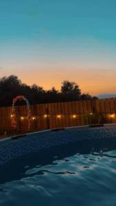 a swimming pool with the sunset in the background at Cottage Orion in Sakramulo