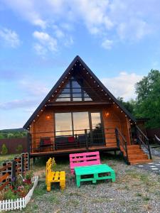 a small house with colorful furniture in front of it at Cottage Orion in Sakramulo