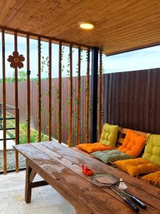 a patio with a wooden table and a couch at Cottage Orion in Sakramulo +4 photos