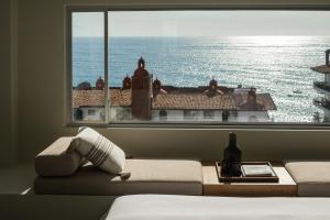 a bedroom with a window with a view of the ocean at The Tryst Puerto Vallarta LGBT Hotel in Puerto Vallarta