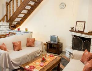 a living room with a couch and a tv at Dreamcatcher Maizonette No. 3 in Kalavrita