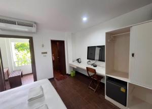 a white room with a desk with a tv and a bed at Hotel Park Star Premium Rooms in Tājganj