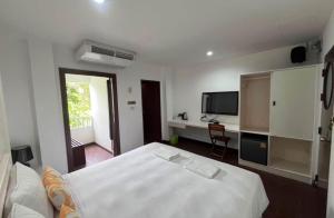 a bedroom with a bed and a desk with a television at Hotel Park Star Premium Rooms in Tājganj