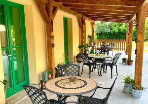 a patio with tables and chairs and a green door at Podere Cafasso Country House in Paestum