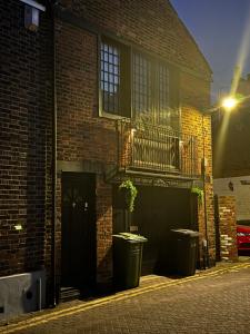 a brick building with two trash cans in front of it at The workshop in King's Lynn