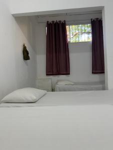 a bedroom with a white bed and a window at Cantinho do amor in Vitória
