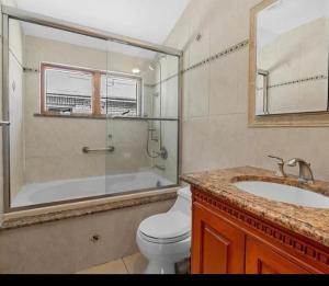ein Badezimmer mit Toilette, Dusche und Waschbecken in der Unterkunft Nyc condo in Oakland Gardens