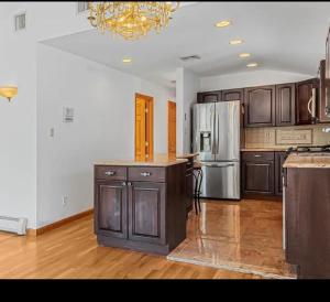 eine große Küche mit Holzboden und Kühlschrank in der Unterkunft Nyc condo in Oakland Gardens