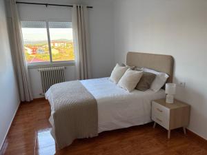 a bedroom with a white bed and a window at Alma de Lemos - Apartamento Ribeira Sacra in Monforte de Lemos