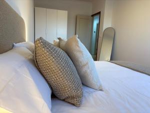 a pile of pillows sitting on top of a bed at Alma de Lemos - Apartamento Ribeira Sacra in Monforte de Lemos +3 photos