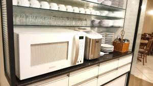 a microwave oven on a shelf in a kitchen at Bravo City Hotel Campinas in Campinas