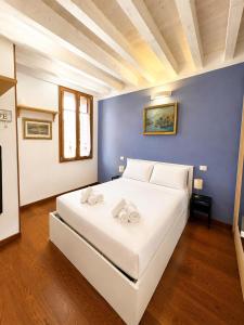 a large white bed in a room with a blue wall at Palazzo Degli Affreschi - Luxury Villa Verona in Verona