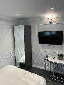 ein Schlafzimmer mit Bett, Fernseher und Tisch in der Unterkunft awesome studio flat in Welling