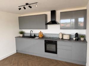 a kitchen with white cabinets and a counter top at Modern Parking Nearby Stores in Swinton