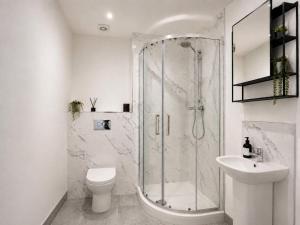 a bathroom with a shower and a toilet and a sink at Modern Parking Nearby Stores in Swinton