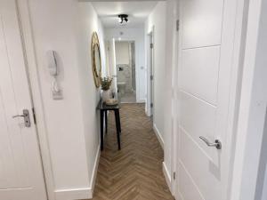 a hallway with a door and a table with a mirror at Modern Parking Nearby Stores in Swinton