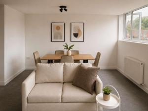 a living room with a couch and a table at Modern Parking Nearby Stores in Swinton +4 photos