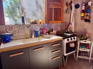 a small kitchen with a sink and a stove at JAGATÁ- Nossa comunidade in Igatu