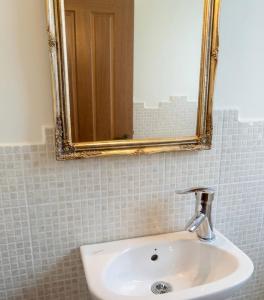 a bathroom with a sink and a mirror at Dreamcatcher Maizonette No. 3 in Kalavrita +12 photos