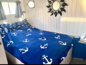 a bed with a blue comforter with white dorses on it at Péniche Mary in Reyssouze