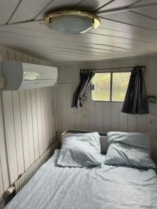 a bedroom with a bed in a trailer at Péniche Mary in Reyssouze