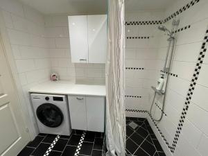 a washing machine in a bathroom with a shower at Family home in Greve
