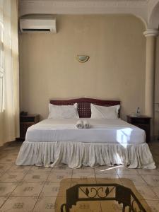 a bedroom with a large bed with white sheets and pillows at Samana hotel ukonga in Dar es Salaam