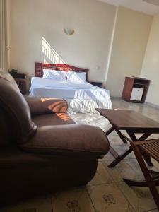 a living room with a couch and a bed at Samana hotel ukonga in Dar es Salaam