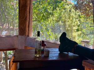 a bottle of wine sitting on a table in front of a window at JAGATÁ- Nossa comunidade in Igatu +7 photos