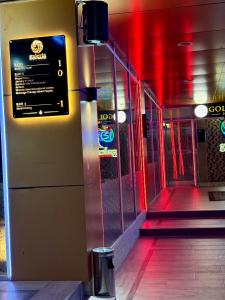 an empty hallway with red lights on a building at Gold City Hotel by Erebara in Debar