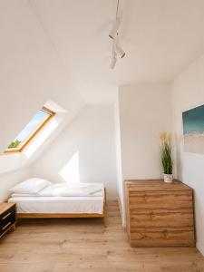a white bedroom with a bed and a window at Sunrise Marina Domki Mielno- Ferienhaus in Mielenko +49 photos