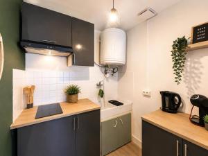a kitchen with black cabinets and a counter top at Le Clos Castinet in Bollène