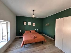 a bedroom with green walls and a bed with orange sheets at Le Clos Castinet in Bollène