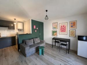 a living room with a couch and a table at Le Clos Castinet in Bollène