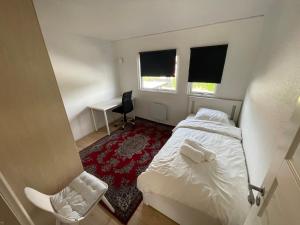 a small bedroom with a bed and a desk at Family home in Greve