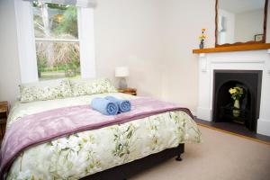 a bedroom with a bed with two towels on it at Cath's cottage in Diamond Harbour